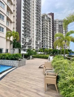 a patio with chairs and palm trees and buildings at The Carly Suite in Manila