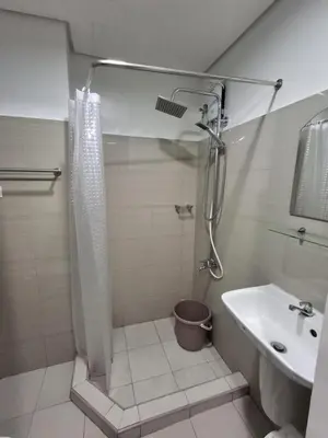 a bathroom with a shower and a sink at Staycation Modern & Convenient in Tubigan