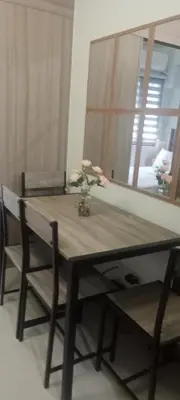 a wooden table with two chairs and a mirror at Staycation Modern & Convenient in Tubigan