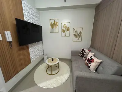 a living room with a couch and a table at Staycation Modern & Convenient in Tubigan