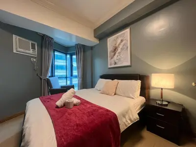 a bedroom with a bed with a teddy bear on it at 2BR Grand Riviera Suites by MrSayla in Manila
