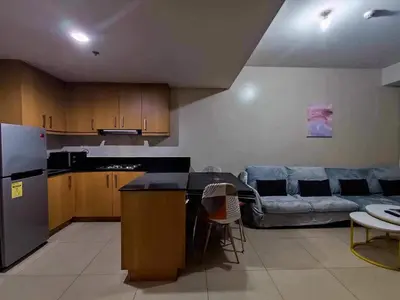 a kitchen and a living room with a couch at 2bedroom with big balcony 1046D pool view in Manila