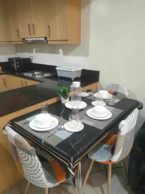 a table with plates and glasses on it in a kitchen at 2bedroom with big balcony 1046D pool view in Manila