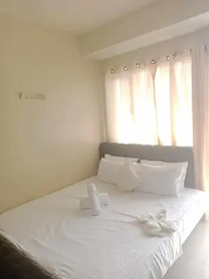 a white bed with a stuffed animal sitting on it at 2bedroom with big balcony 1046D pool view in Manila