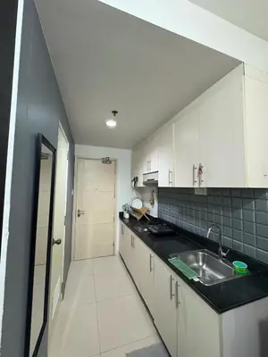 a kitchen with white cabinets and a sink at Sea Residences by Laine in Manila
