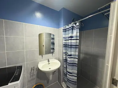 a bathroom with a sink and a mirror and a shower at Sea Residences by Laine in Manila