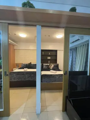 a bedroom with two beds and a flat screen tv at 2bedroom with 2balcony with pool view 1633-34 in Manila