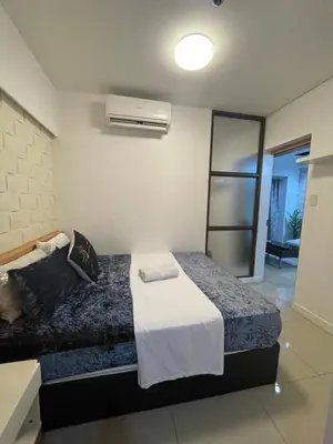 a bedroom with a bed in a room with a fan at 2bedroom with 2balcony with pool view 1633-34 in Manila