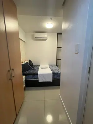 a small room with a bed and a small door at 2bedroom with 2balcony with pool view 1633-34 in Manila