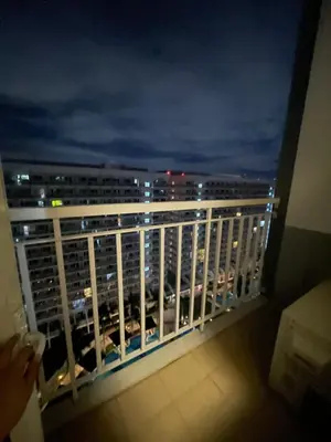 a balcony with a view of a city at night at 2bedroom with 2balcony with pool view 1633-34 in Manila