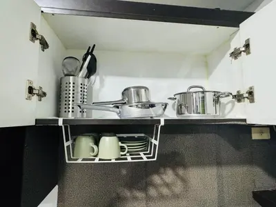 a kitchen with a shelf with pots and pans at Stamford Residences Fully-furnished in Manila