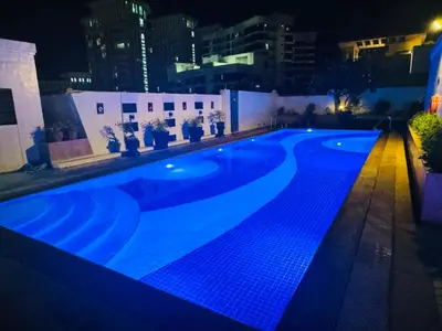 a swimming pool lit up at night at Stamford Residences Fully-furnished in Manila