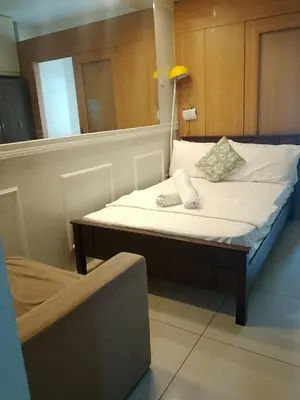 a bedroom with a bed with a lamp and a chair at 1bedroom pool view with big balcony in Manila