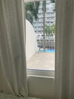 an open window with a view of a building at 1bedroom pool view with big balcony in Manila