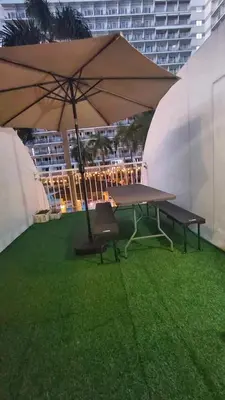 a picnic table with an umbrella and a bench at 1bedroom pool view with big balcony in Manila