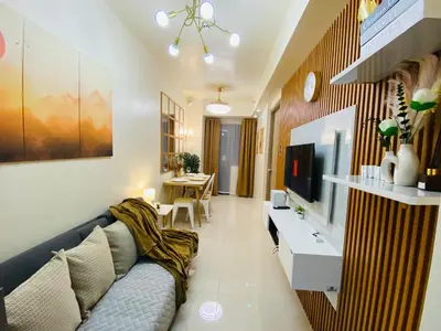 a living room with a couch and a tv at Condotel at S Residences near SM MOA, SMX, Arena, NAIA Airport in Manila