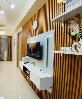a living room with a television on a wall at Condotel at S Residences near SM MOA, SMX, Arena, NAIA Airport in Manila