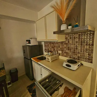a small kitchen with a sink and a refrigerator at Azure Urban Resort Residences by Moldez Staycation in Manila