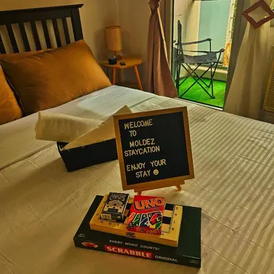 a bed with a welcome to world championship book on it at Azure Urban Resort Residences by Moldez Staycation in Manila