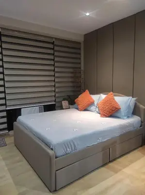 a bedroom with a bed with orange and blue pillows at Cozy Apartment City & Mountain View with balcony FREE use of pools sauna and sunbathing in Manila
