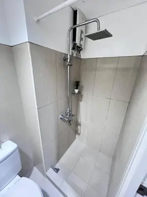 a shower stall in a bathroom with a toilet at Unistay SHELL Residences Amazing Pool view near MOA in Manila