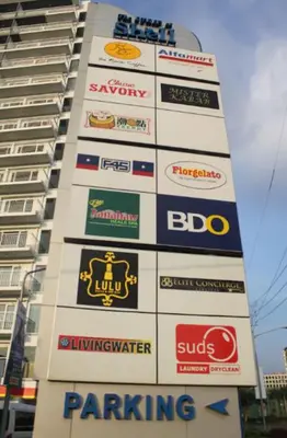 a tall building with lots of signs on it at Unistay SHELL Residences Amazing Pool view near MOA in Manila