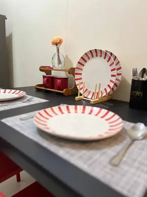 a table with red and white plates on a table at Unistay SHORE 3 Tower 2 Pool View Cozy Suite in Manila
