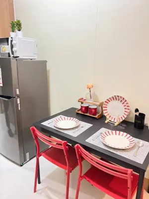 a table with two red chairs next to a refrigerator at Unistay SHORE 3 Tower 2 Pool View Cozy Suite in Manila