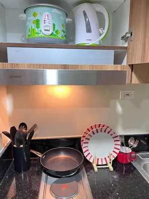a kitchen counter with a stove with a pot and a fan at Unistay SHORE 3 Tower 2 Pool View Cozy Suite in Manila