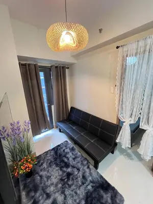 a living room with a couch and a table at Unistay SHORE 3 Tower 2 Pool View Cozy Suite in Manila
