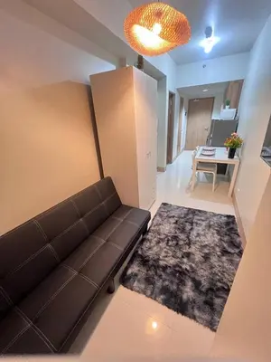 a living room with a couch and a table at Unistay SHORE 3 Pool view w Balcony near MOA in Manila