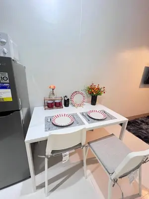 a white table with two paper plates and a chair at Unistay SHORE 3 Pool view w Balcony near MOA in Manila