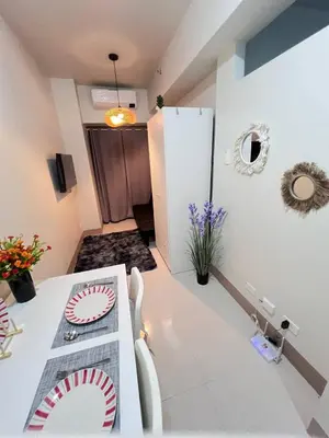 a room with a table with a plate on it at Unistay SHORE 3 Pool view w Balcony near MOA in Manila