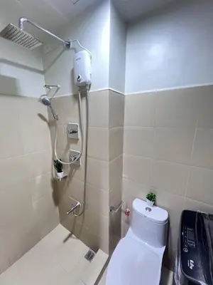 a bathroom with a shower and a toilet in it at Unistay SHORE 3 Tower 2 10th Floor w Balcony Pool View in Manila