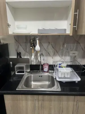a kitchen sink with a dish drying rack next to it at Shore 2 Residences Executive Suite by JMS in Manila