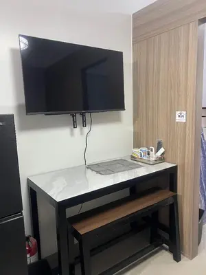 a desk with a television on a wall at Shore 2 Residences Executive Suite by JMS in Manila