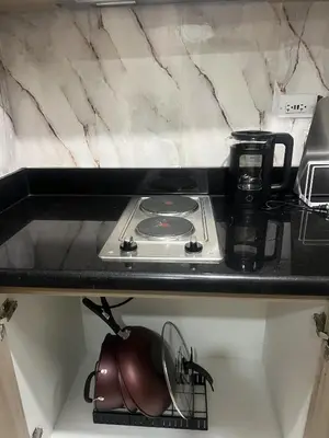 a kitchen counter with a stove and a tea kettle at Shore 2 Residences Executive Suite by JMS in Manila