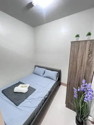 a bedroom with a bed with blue sheets and purple flowers at Unistay SHORE 3 Poolview w Balcony in Manila