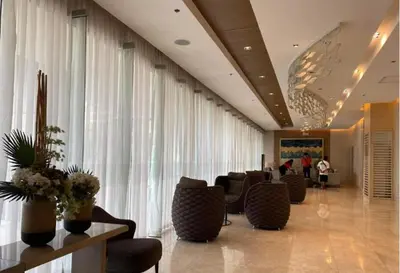 a lobby with a waiting room with chairs and curtains at Unistay SHORE 3 Poolview w Balcony in Manila
