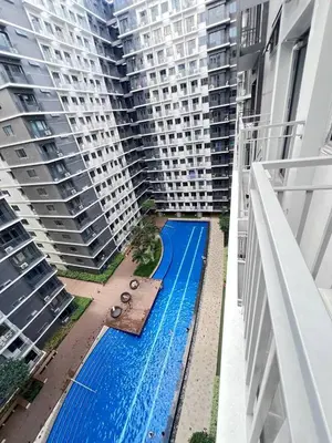 a swimming pool in the middle of two tall buildings at Unistay SHORE 3 Poolview w Balcony in Manila