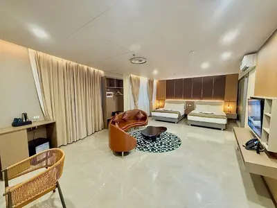 a living room with a chair and a couch at Skyport Hotel in Manila