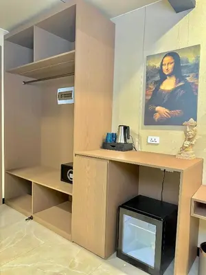 a room with a desk with a picture of a woman at Skyport Hotel in Manila