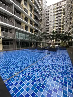 a large blue swimming pool in front of a building at 1BR Executive Suite Beside Okada & Solaire - 4pax in Manila