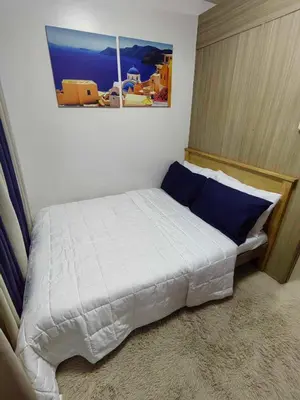 a bedroom with a white bed with blue pillows at Shore Residences in Manila