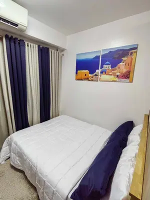 a bedroom with a bed and a picture on the wall at Shore Residences in Manila