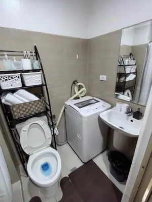 a small bathroom with a toilet and a sink at Shore Residences in Manila