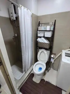 a small bathroom with a toilet and a shower at Shore Residences in Manila