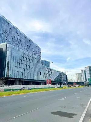 a large glass building with a road in front of it at Spacious 2BR Luxury Suite across Okada, Airport in Manila