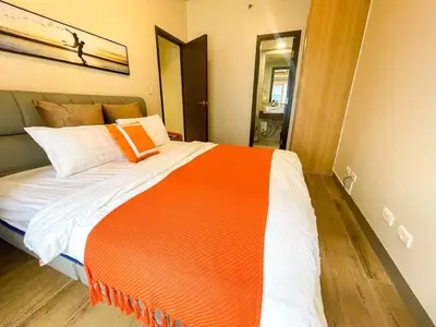 an orange and white bed in a room at Spacious 2BR Luxury Suite across Okada, Airport in Manila