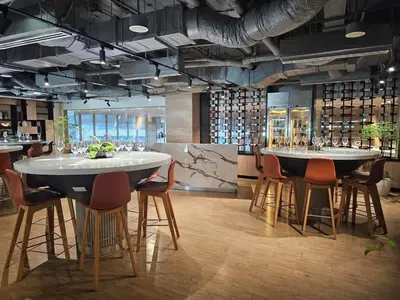 a restaurant with two tables and chairs and a bar at The Residences at BCCT by Stays PH Cozy retreat with hotel-style comforts and convenience, best location in BGC in Manila